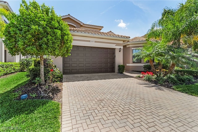 10079 Chesapeake Bay Dr, Fort Myers, FL 33913 - mediterranean / spanish-style house featuring a tiled roof, a garage, decorative driveway, and stucco siding