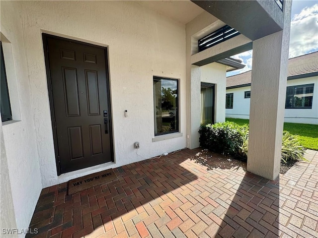 view of exterior entry featuring stucco siding