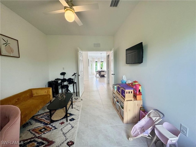 living area featuring light tile patterned floors, ceiling fan, and visible vents