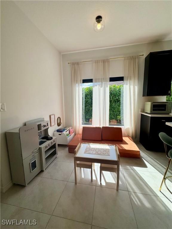 living room with light tile patterned flooring and a toaster
