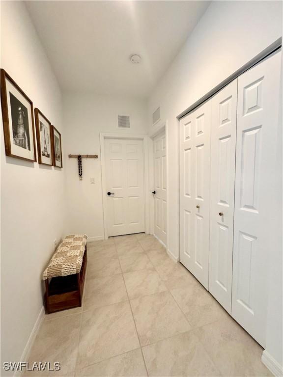 hall with baseboards and visible vents