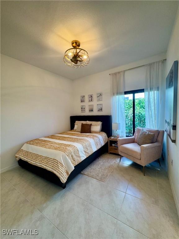 bedroom featuring light tile patterned flooring and baseboards