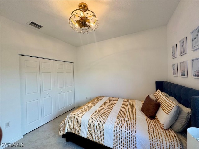 bedroom with light tile patterned floors, a closet, and visible vents