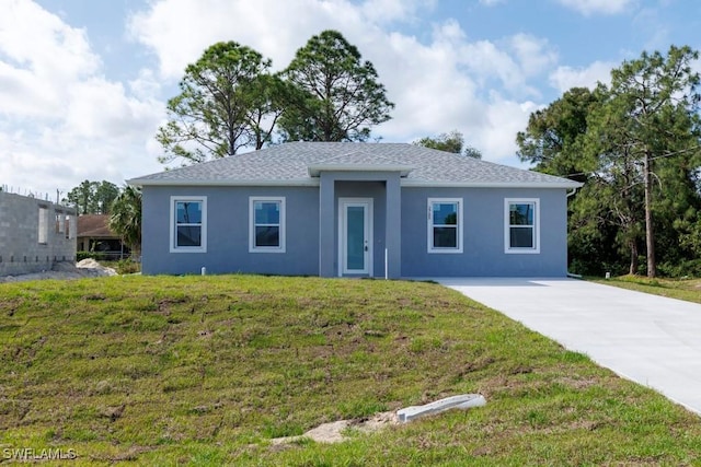 single story home featuring roof with shingles, a front yard, driveway, and stucco siding