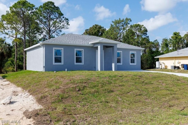 ranch-style home featuring a front yard and stucco siding