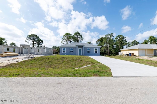 ranch-style house featuring concrete driveway and a front lawn