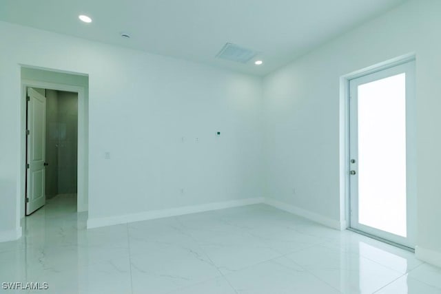 empty room featuring marble finish floor, baseboards, and recessed lighting