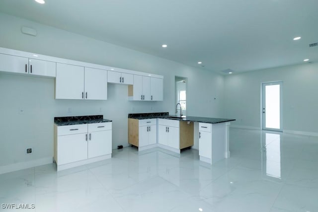 kitchen with white cabinets, recessed lighting, and a peninsula