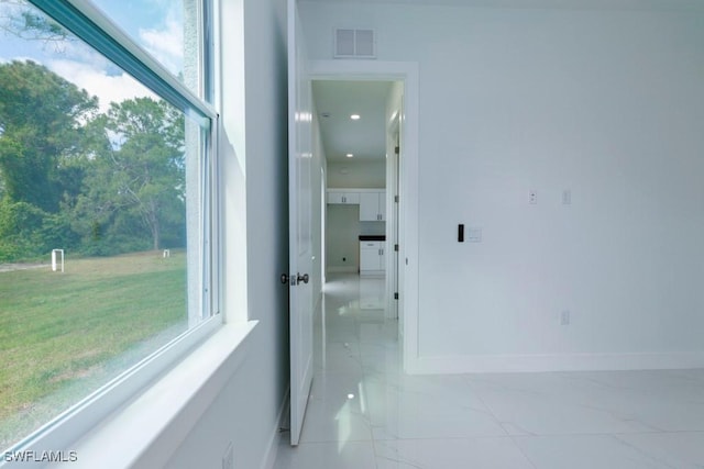 corridor with visible vents, marble finish floor, and a healthy amount of sunlight