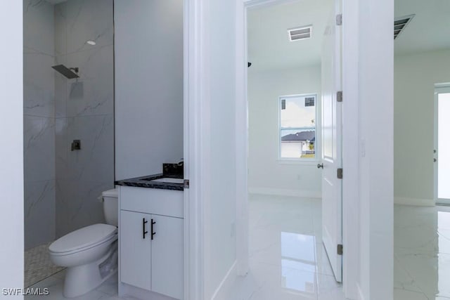 bathroom featuring visible vents, toilet, vanity, a marble finish shower, and marble finish floor