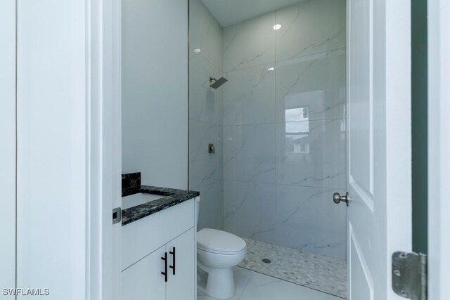 full bath with toilet, marble finish floor, vanity, and a marble finish shower