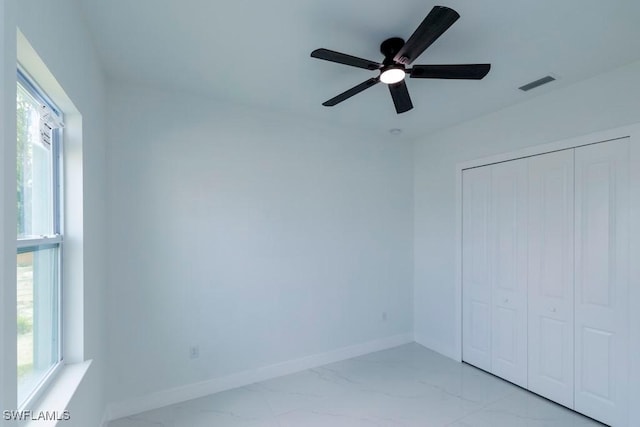 spare room with visible vents, marble finish floor, baseboards, and ceiling fan