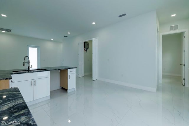 kitchen with a sink, visible vents, recessed lighting, and marble finish floor