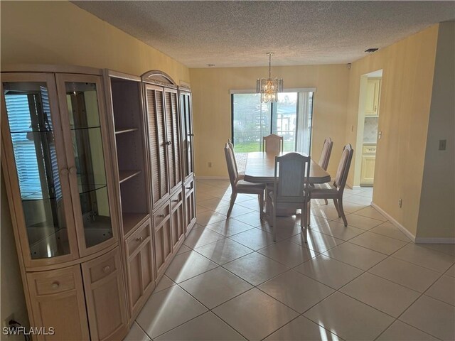 4628 SW 18th Ave, Cape Coral, FL 33914 - dining space with baseboards, a textured ceiling, an inviting chandelier, and light tile patterned floors