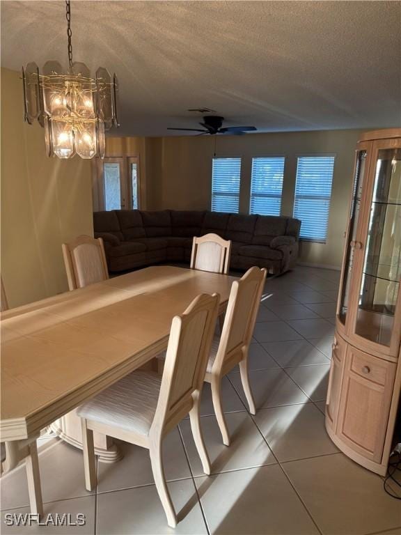 4628 SW 18th Ave, Cape Coral, FL 33914 - dining space with a textured ceiling, light tile patterned floors, and ceiling fan with notable chandelier