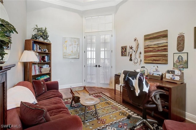 living room with french doors, crown molding, wood finished floors, and baseboards