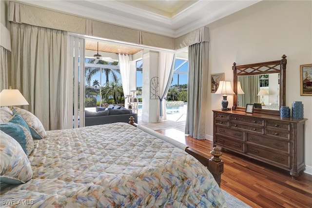 bedroom featuring access to outside, wood finished floors, baseboards, and ornamental molding