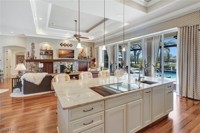kitchen featuring open floor plan, black electric stovetop, and crown molding