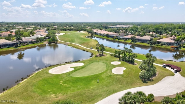 drone / aerial view featuring a residential view, view of golf course, and a water view