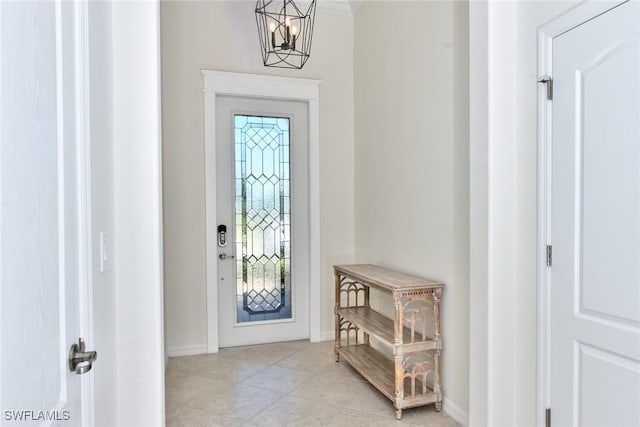 entryway featuring tile patterned flooring, a notable chandelier, and baseboards