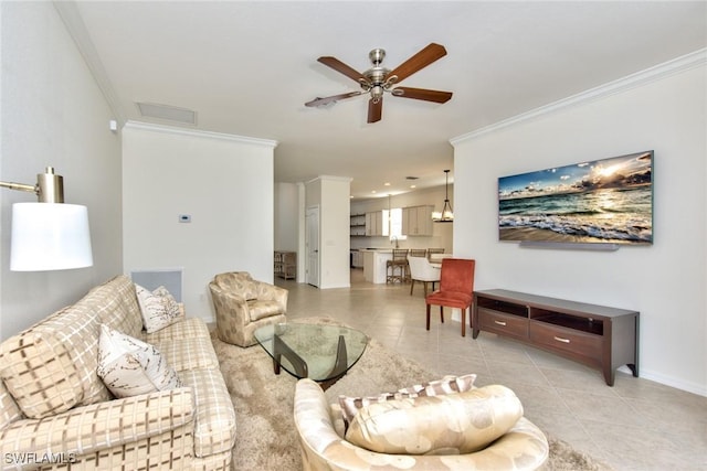 living room featuring light tile patterned flooring, crown molding, baseboards, and ceiling fan
