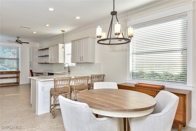 dining space with ornamental molding, ceiling fan with notable chandelier, and recessed lighting