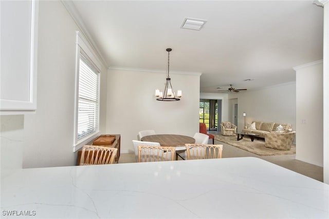 dining space with ceiling fan with notable chandelier, visible vents, and crown molding