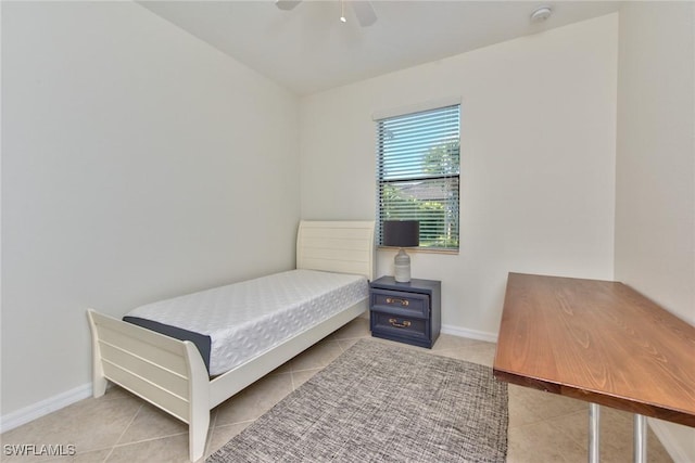 tiled bedroom featuring baseboards and ceiling fan