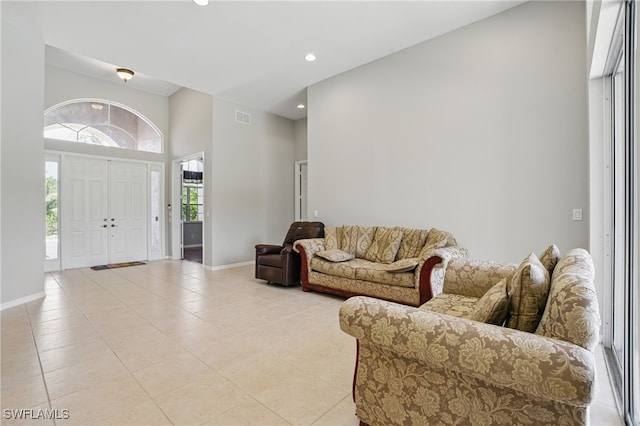 510 13th St NW, Naples, FL 34120 - living room featuring a high ceiling, light tile patterned floors, baseboards, and visible vents