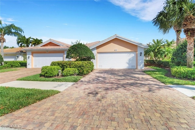 7933 Umberto Ct, Naples, FL 34114 - view of front of property with decorative driveway, a tiled roof, stucco siding, and a garage