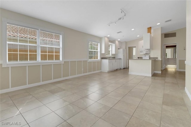7933 Umberto Ct, Naples, FL 34114 - unfurnished living room with light tile patterned flooring, vaulted ceiling, and visible vents