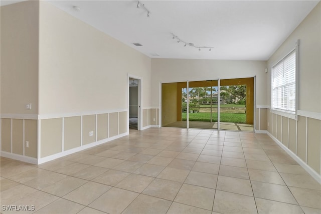 7933 Umberto Ct, Naples, FL 34114 - empty room featuring lofted ceiling, rail lighting, and light tile patterned floors