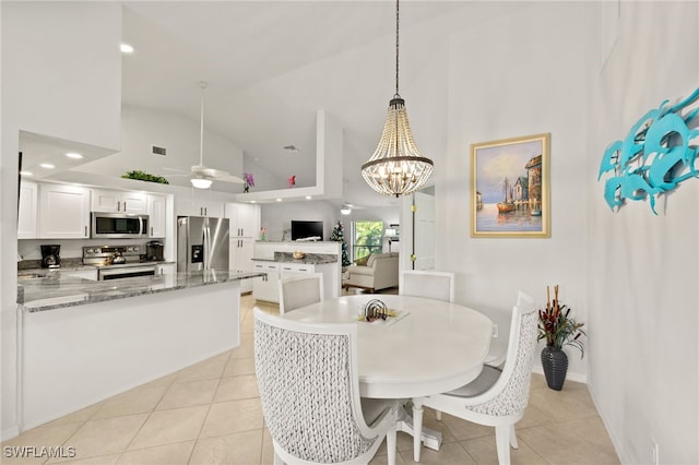 dining area featuring light tile patterned floors, high vaulted ceiling, ceiling fan with notable chandelier, and visible vents