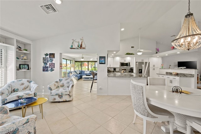 dining area with vaulted ceiling, light tile patterned floors, ceiling fan with notable chandelier, built in shelves, and visible vents