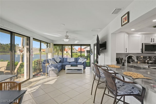 sunroom / solarium featuring outdoor lounge area, a ceiling fan, visible vents, and a sink