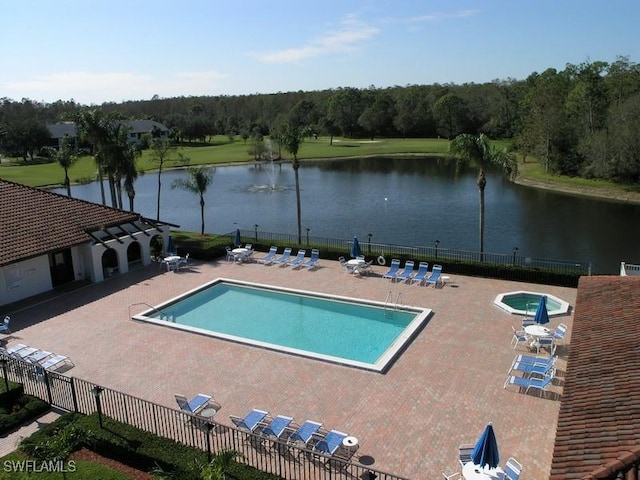 community pool featuring a patio, a water view, and fence