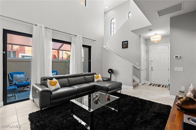 1338 Kendari Ter, Naples, FL 34113 - living room featuring stairway, light tile patterned floors, a towering ceiling, and baseboards