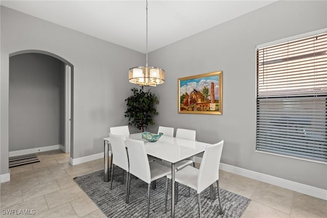1338 Kendari Ter, Naples, FL 34113 - dining area featuring arched walkways, light tile patterned floors, a notable chandelier, and baseboards