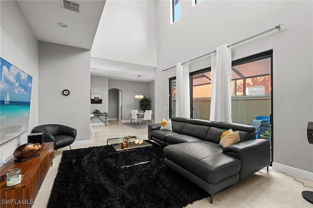 1338 Kendari Ter, Naples, FL 34113 - living room with baseboards, light tile patterned floors, a high ceiling, visible vents, and arched walkways