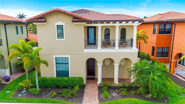 1338 Kendari Ter, Naples, FL 34113 - mediterranean / spanish-style home with stucco siding, a tile roof, and a balcony
