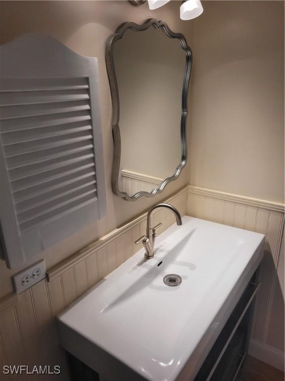 bathroom with a wainscoted wall and a sink