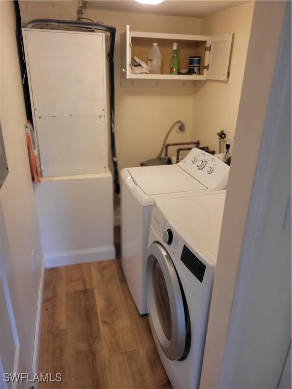 laundry room with separate washer and dryer, laundry area, light wood-style flooring, and baseboards