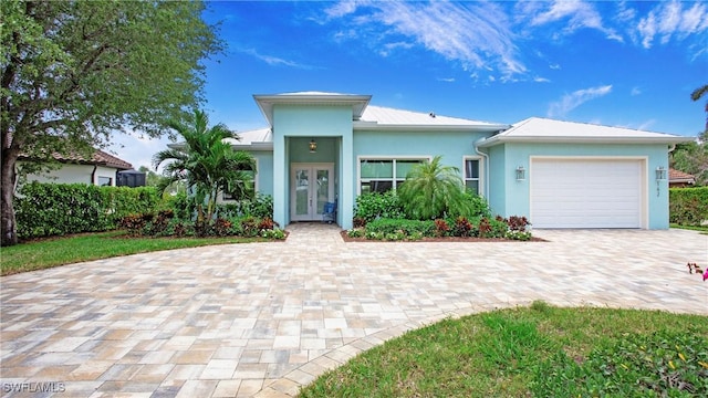 162 Windward Cay, Naples, FL 34114 - view of front facade featuring a garage, french doors, decorative driveway, and stucco siding
