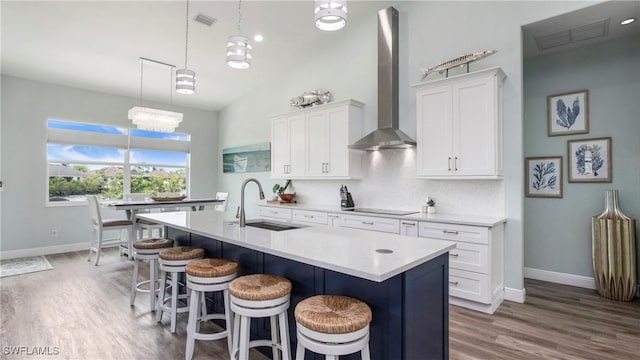 162 Windward Cay, Naples, FL 34114 - kitchen featuring a kitchen breakfast bar, wall chimney range hood, a sink, a center island with sink, and backsplash