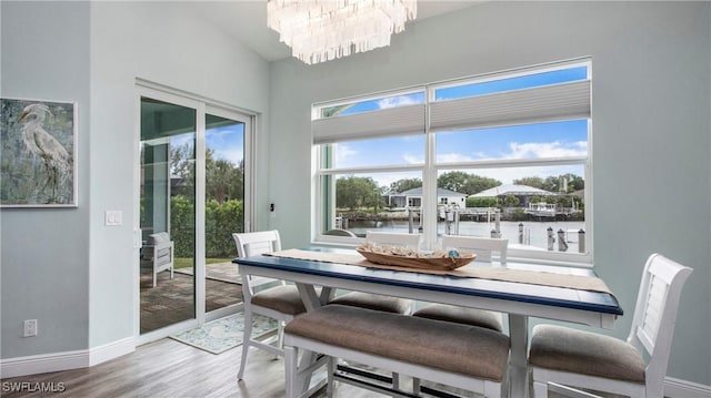 162 Windward Cay, Naples, FL 34114 - dining area with a chandelier, wood finished floors, baseboards, and vaulted ceiling