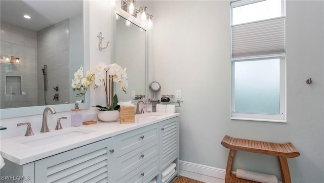 162 Windward Cay, Naples, FL 34114 - full bathroom featuring double vanity, a tile shower, baseboards, and a sink
