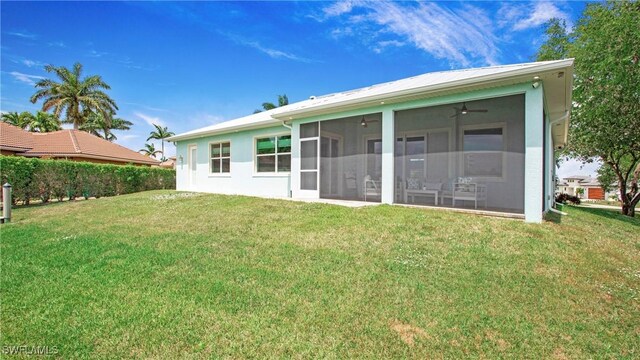 162 Windward Cay, Naples, FL 34114 - back of house with a sunroom, stucco siding, and a lawn
