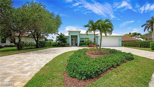 162 Windward Cay, Naples, FL 34114 - view of front of property with stucco siding, french doors, decorative driveway, a front yard, and a garage