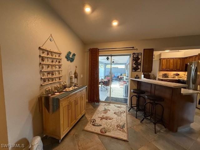 408 SE 19th Ln, Cape Coral, FL 33990 - kitchen with a kitchen breakfast bar, a peninsula, and freestanding refrigerator
