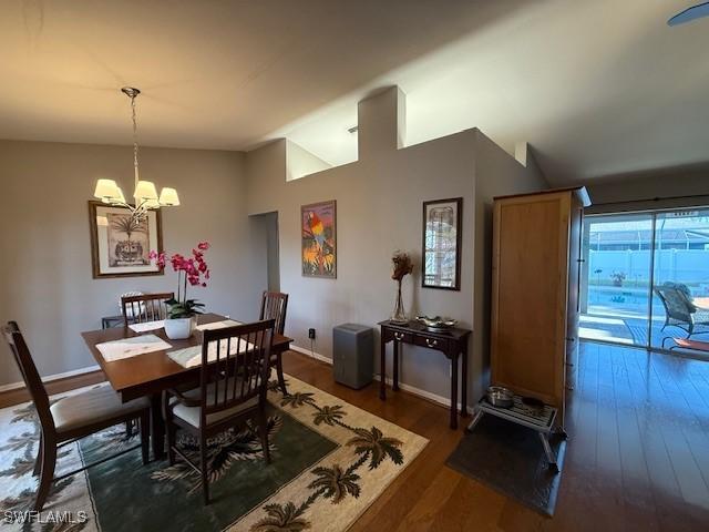 408 SE 19th Ln, Cape Coral, FL 33990 - dining area featuring baseboards, vaulted ceiling, wood finished floors, and a chandelier
